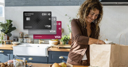 A smiling woman in a kitchen unpacking groceries with CIBC credit cards in the background