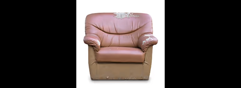 Old brown single-seat couch with tears in it